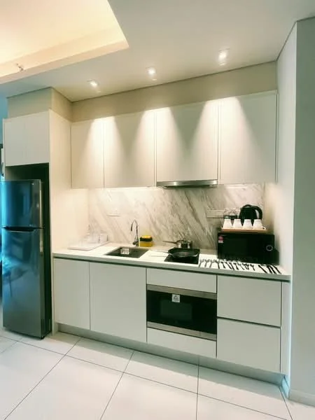 Kitchen features: white cabinetry, marble backsplash, stainless-steel fridge, single-bowl stainless-steel sink, chrome pull-down faucet, built-in oven, 4-burner gas hob, recessed downlights, white tile flooring, countertop with overhang, coffee machine, kettle, toaster; style: modern.