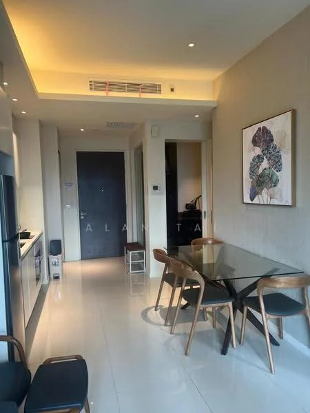 Dining features: glass dining table, 4 wooden dining chairs, white tiled flooring, recessed ceiling lights, wall-mounted artwork, neutral wall colour, open layout to kitchen, floor-to-ceiling windows; style: modern. Kitchen features: stainless-steel fridge, built-in cabinetry, white countertops, kitchen island, open shelving; style: modern. Room features: neutral wall colour, recessed ceiling lights.