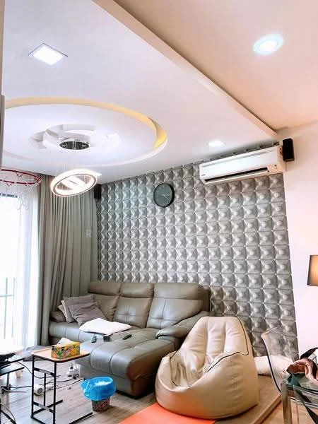 Living features: grey leather sectional sofa, beige bean bag chair, round ceiling light fixture, recessed LED downlights, wall-mounted split AC, textured feature wall with 3D panels, curtains, clock on wall, coffee table, area rug; style: modern.