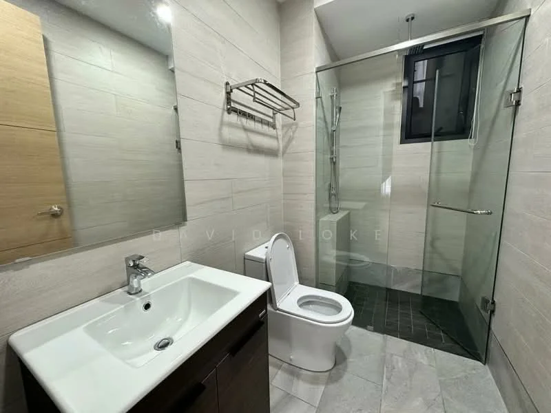 Bathroom features: single-sink vanity with dark wood cabinet, white ceramic sink, chrome basin mixer faucet, framed mirror above sink, one-piece toilet, walk-in shower with glass enclosure, rain shower head, grey tile flooring, light beige wall tiles, towel rack, window for natural light; style: modern.
