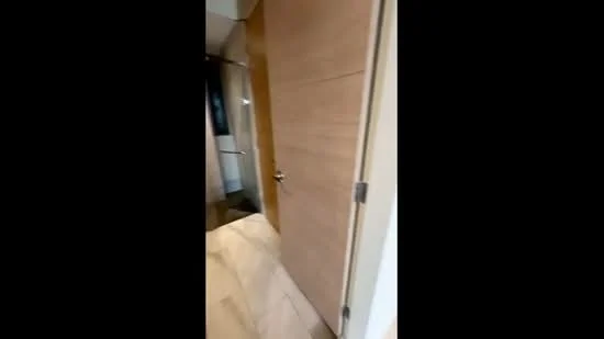 Room features: wooden door, light wood paneling, tile flooring, neutral wall color, glass shower enclosure, modern light fixtures; style: modern.