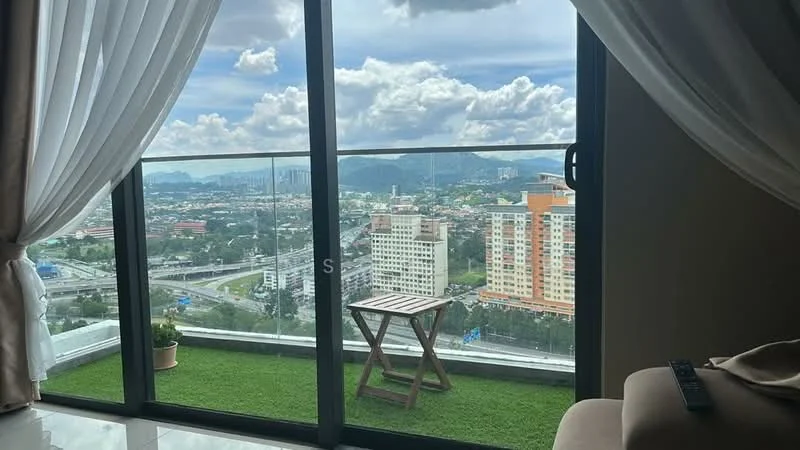 Room features: floor-to-ceiling windows, glass balcony railing, green artificial grass flooring, small wooden table, potted plant, curtains, city skyline view, mountain view; style: modern; view: city.