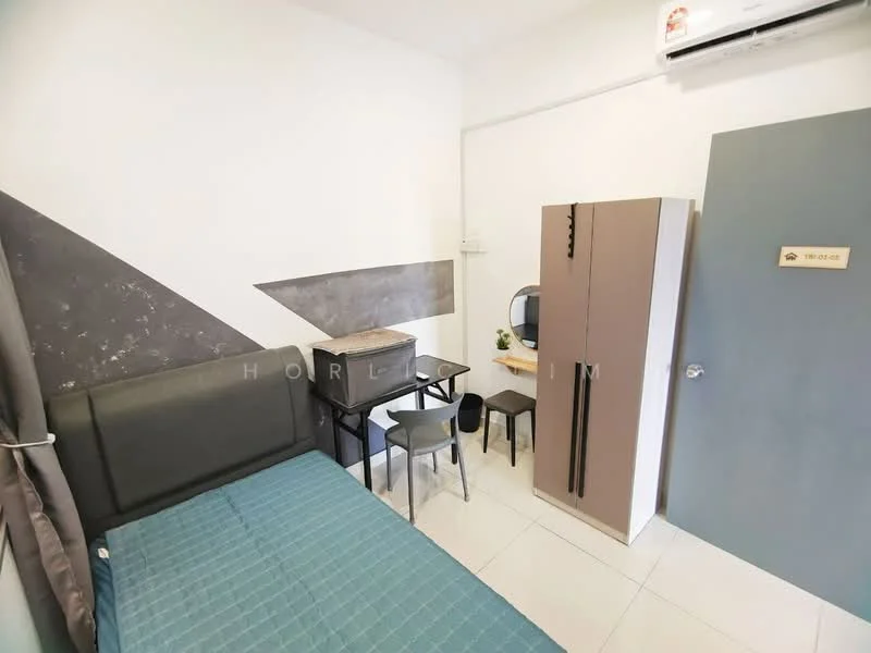 Bedroom features: single bed with grey upholstered headboard, blue bedspread, white walls with grey accent wall, white tiled flooring, built-in wardrobe with two-tone doors, small round dining table with two chairs, wall-mounted mirror, air conditioning unit, door with room number plaque; style: modern.