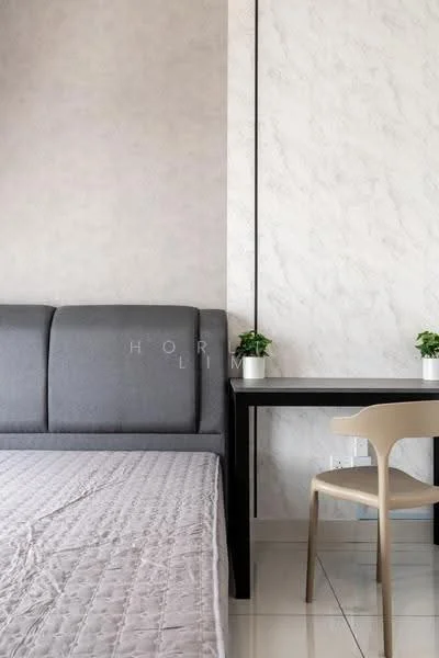 Room features: grey upholstered sofa, light-colored textured wall, white marble accent wall, white tiled flooring, small potted plants on table, black desk, light-colored chair, bed with quilted cover; style: modern.