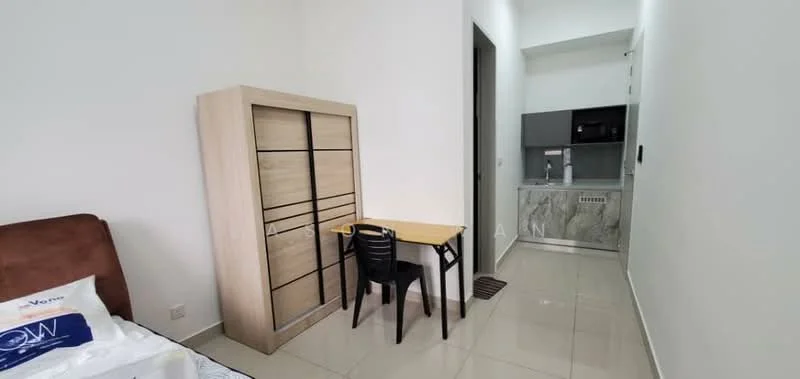 Room features: white painted walls, glossy tile flooring, brown upholstered bed, wooden wardrobe with sliding doors, small dining table with black chair, kitchenette with grey cabinetry, stainless-steel sink, built-in microwave, countertop with stone finish; style: modern.