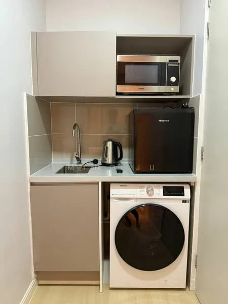 Laundry features: single-bowl stainless-steel sink, chrome pull-down faucet, grey cabinetry, white countertop, built-in microwave, black mini fridge, front-load washing machine, kettle; style: modern.