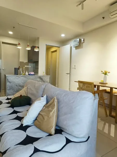 Living features: 3-seater fabric sofa in light grey, decorative cushions in various colors, coffee table, pendant lights above kitchen island, wall-mounted split AC, tile flooring, neutral painted walls, open layout to kitchen and dining area; style: modern. Kitchen features: kitchen island with stone countertop, stainless-steel sink, built-in cabinetry, refrigerator, oven, cooktop, pendant lighting, neutral color scheme; style: modern. Dining features: wood dining table, wooden dining chairs, decorative vase with flowers, neutral color scheme; style: modern.
