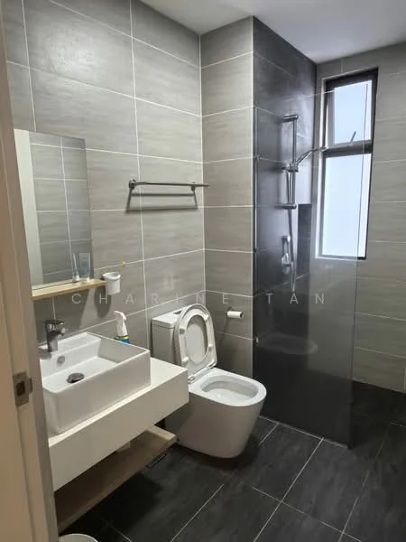 Bathroom features: grey tiled walls, black tiled flooring, single-sink vanity with wood cabinet, chrome basin mixer faucet, framed mirror above sink, one-piece toilet, walk-in shower with glass enclosure, handheld shower, shower wall with grey tiles, towel rack, window for natural light; style: modern.