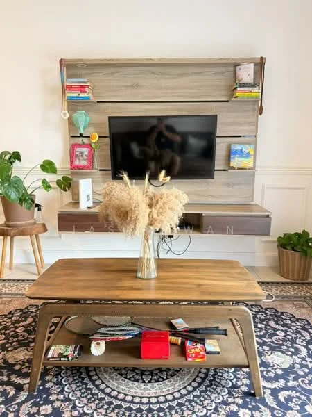 Living features: wall-mounted TV, wooden coffee table, decorative vase with dried flowers, bookshelf with various books and decor, area rug with geometric pattern, potted plant, wooden side table, wall panel with shelves; style: modern.