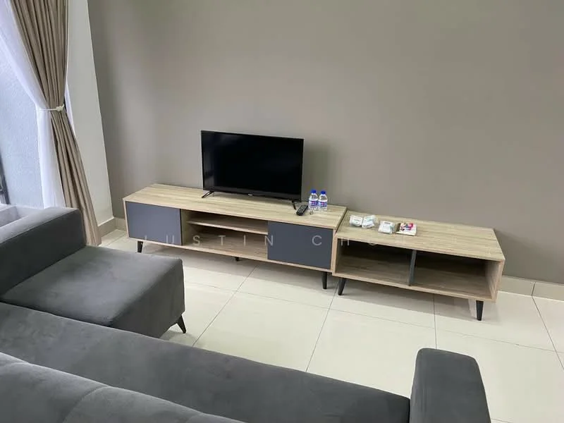 Living features: grey fabric sectional sofa, wooden TV console with grey drawers, wall-mounted TV, ceramic tile flooring, neutral painted walls, curtains, two bottles of water on the console, remote control on the console; style: modern.