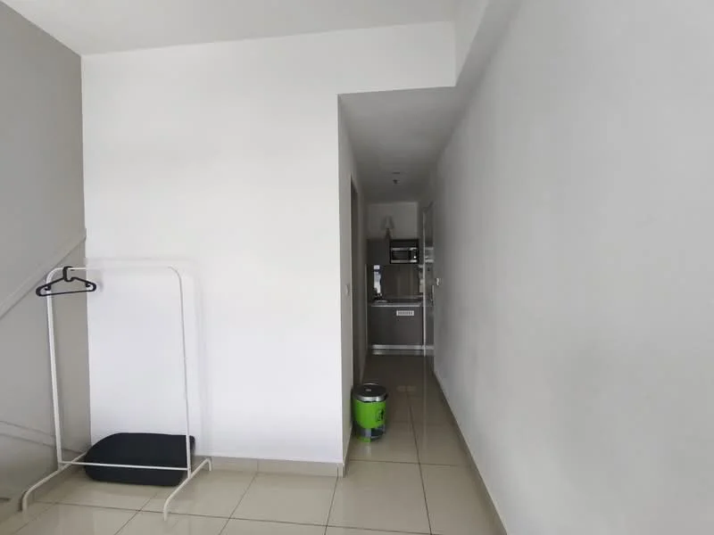 Room features: white painted walls, glossy tile flooring, open hallway, staircase visible, coat rack, green trash can, doorway leading to kitchen, neutral color scheme; style: modern.