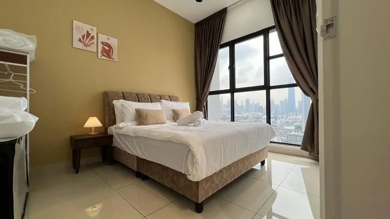 Bedroom features: king-size bed, upholstered headboard, white bedding with decorative pillows, nightstand with lamp, floor-to-ceiling windows, city skyline view, cream painted walls, tile flooring, sheer curtains, built-in wardrobe; style: modern; view: city.