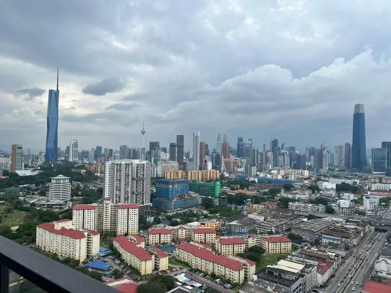 Exterior type: high-rise condominium; features: city skyline view, multiple high-rise buildings, urban landscape, mixed-use development, green spaces visible, various architectural styles, cloudy sky, roadway in foreground; style: modern.