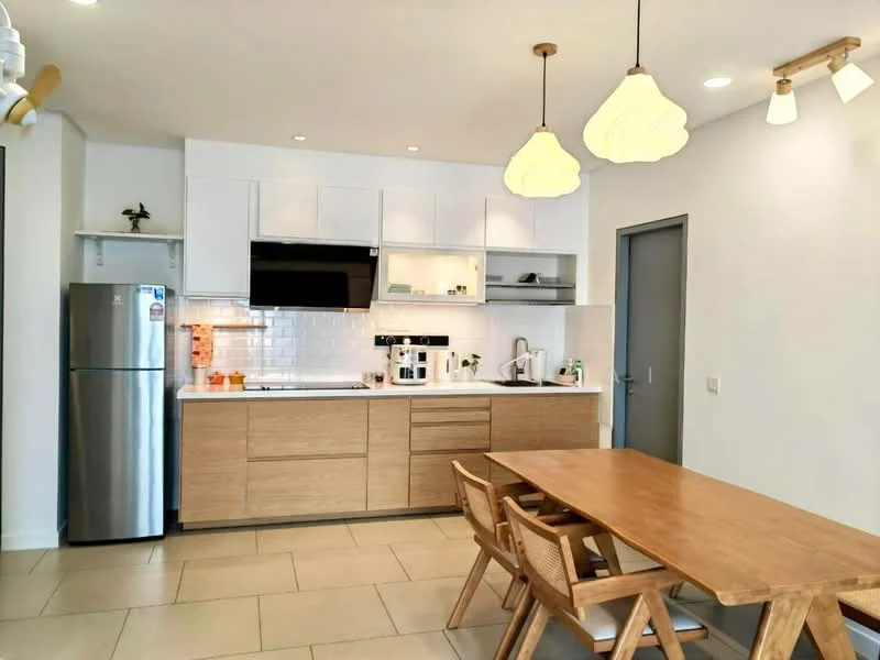 Kitchen features: stainless-steel fridge, built-in oven, freestanding range oven, white shaker cabinets, laminate countertop, white subway tile backsplash, single-bowl stainless-steel sink, chrome pull-down faucet, pendant lighting, recessed downlights, dining table with wooden finish, wooden dining chairs; style: modern.