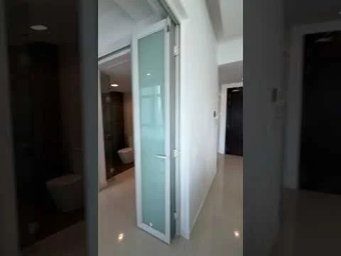 Room features: white painted walls, glossy tile flooring, glass door, door frame, light fixtures, toilet visible, dark wall, neutral color scheme; style: modern.
