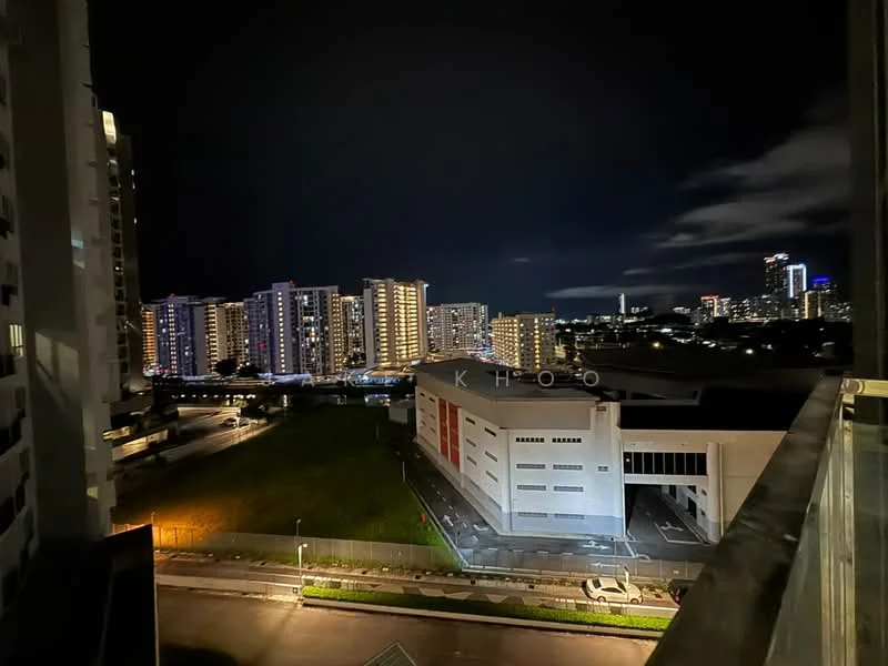 Exterior type: high-rise condominium; features: city skyline view, nighttime lighting, surrounding residential buildings, open green space, street view with road, modern architecture, visible parking area; style: modern.