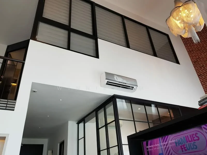 Room features: exposed brick wall, white painted walls, black framed glass partition, wall-mounted split AC, recessed downlights, pendant light fixture, open space layout, high ceiling; style: modern.