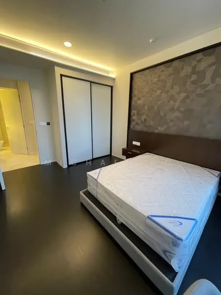 Bedroom features: queen-size bed with mattress, dark wood bed frame, built-in wardrobe with sliding doors, textured accent wall, dark wood flooring, recessed ceiling lights, neutral wall color, doorway leading to bathroom; style: modern.