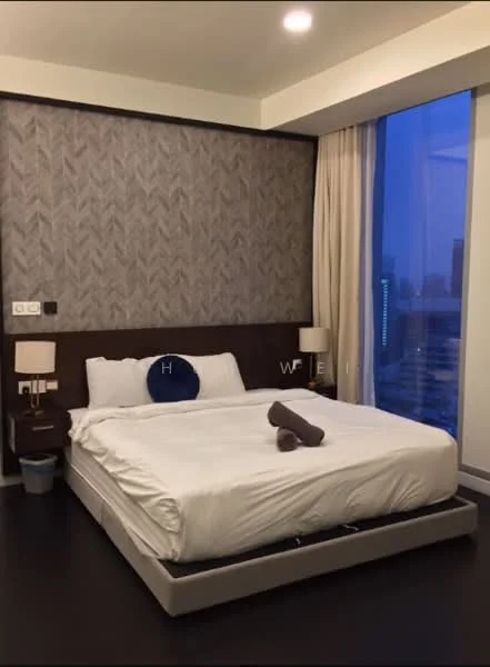 Bedroom features: king-size bed with white bedding, upholstered headboard, two bedside lamps, dark wood nightstands, grey patterned accent wall, floor-to-ceiling windows, curtains, dark wood flooring, decorative throw pillow, rolled towel on bed, wastebasket; style: modern; view: city.