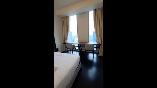 Bedroom features: king-size bed, floor-to-ceiling windows, curtains, wooden flooring, study desk, chair, city view; style: modern; view: city.