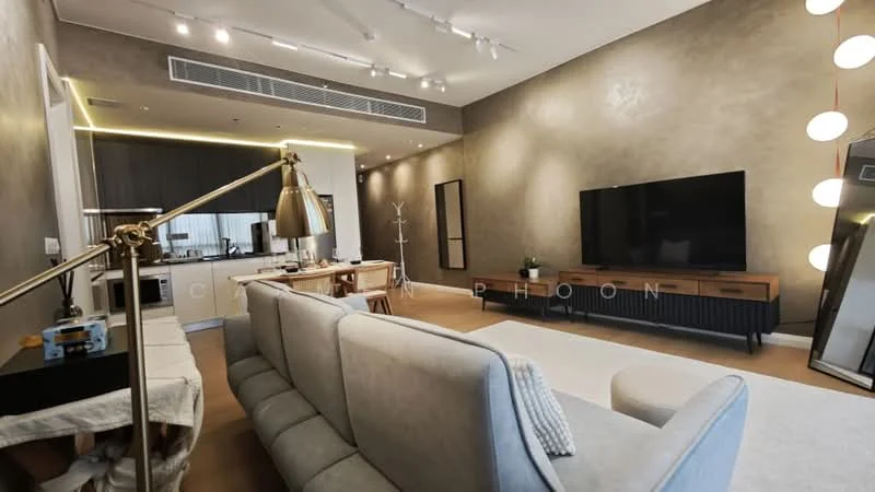 Living features: grey fabric sofa, coffee table, wall-mounted TV, TV console with storage, recessed lighting, pendant light, decorative mirror, wooden flooring, textured accent wall, open layout to kitchen, large windows, area rug; style: modern. Kitchen features: white cabinetry, stainless-steel appliances, kitchen island, bar stools, marble countertop, built-in oven, 4-burner gas hob, extractor hood, double-bowl stainless-steel sink; style: modern.
