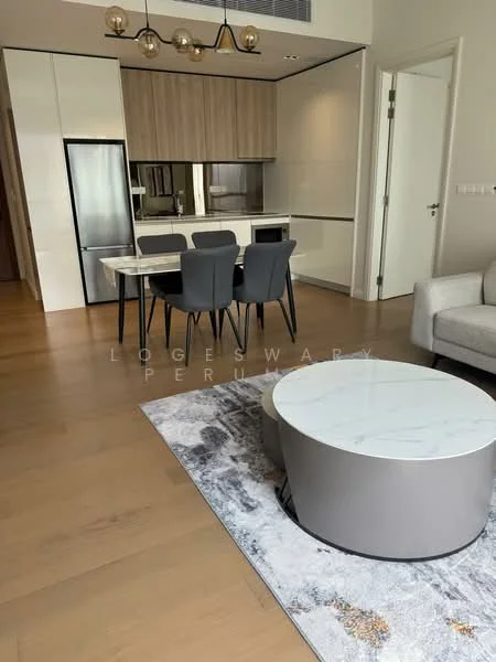 Living features: light wood flooring, white painted walls, recessed downlights, 3-seater fabric sofa in light grey, round coffee table with marble top, area rug with abstract pattern, dining table with 4 black upholstered chairs, kitchenette with built-in cabinetry, stainless-steel fridge, microwave, open-plan layout; style: modern.