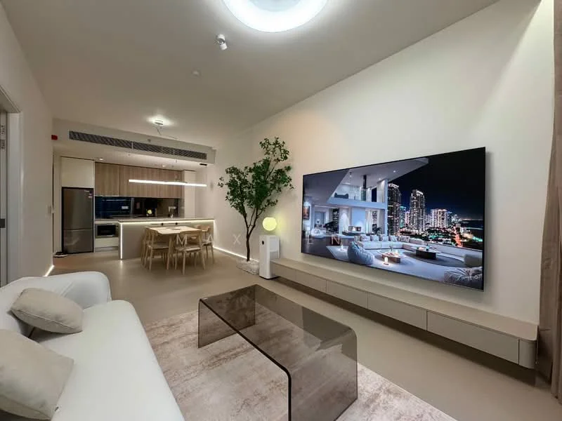 Living features: white walls, recessed ceiling lights, 5-blade ceiling fan with integrated LED light, large wall-mounted TV, glass coffee table, 3-seater fabric sofa in white, area rug with neutral tones, decorative indoor plant, open-plan layout with kitchen visible, floor-to-ceiling windows with city view; style: modern; view: city. Kitchen features: wood cabinetry, kitchen island with seating, stainless-steel fridge, built-in oven, induction cooktop, pendant lighting over island; style: modern.