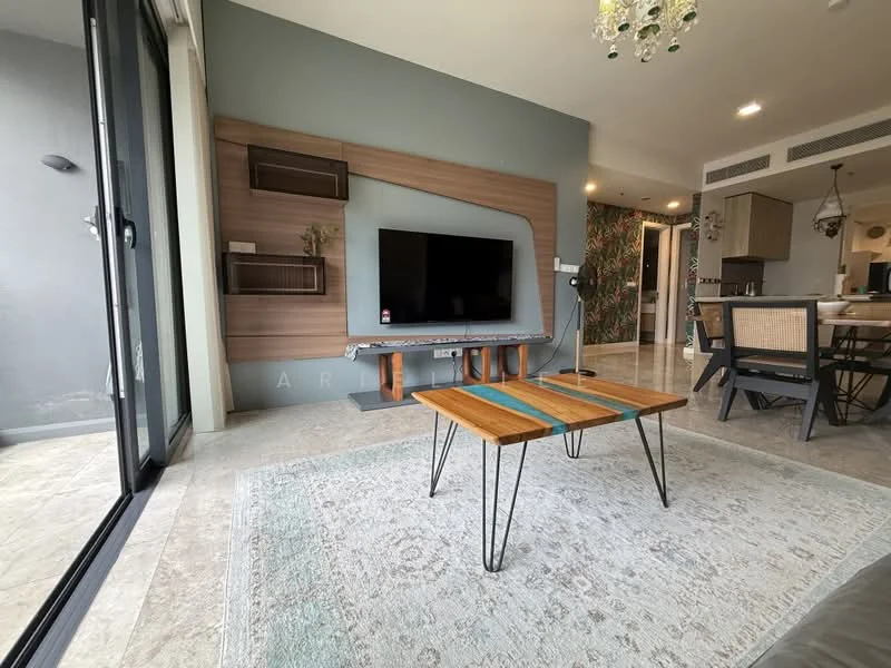 Living features: grey accent wall, wood feature wall with TV mount, flat-screen TV, wooden coffee table with metal legs, area rug with geometric pattern, floor-to-ceiling windows, sliding glass door, recessed downlights, decorative wall with plants, dining area visible in background, ceramic tile flooring; style: modern; view: garden.