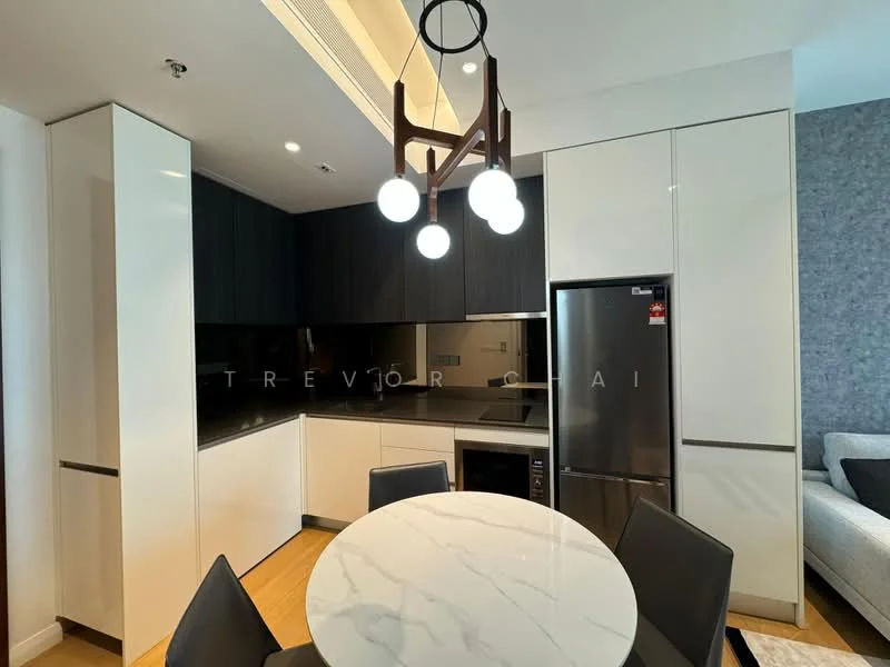 Kitchen features: white cabinetry, black upper cabinetry, black countertop, stainless-steel fridge, built-in microwave, round marble dining table, black upholstered dining chairs, pendant light fixture with three bulbs, wooden flooring, recessed lighting; style: modern.
