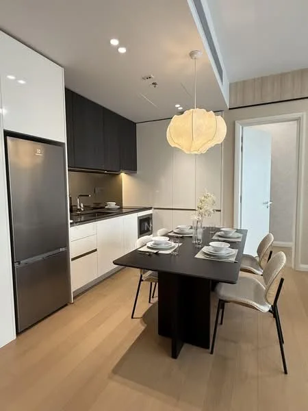Kitchen features: white cabinetry, black countertop, stainless-steel fridge, built-in oven, 4-burner gas hob, single-bowl stainless-steel sink, chrome pull-down faucet, pendant light, dining table for four, upholstered dining chairs, wood flooring, recessed downlights; style: modern.