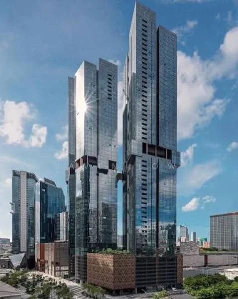 Exterior type: high-rise condominium; features: glass curtain wall, exposed concrete facade, recessed balconies, vertical fins, feature lighting at night, surrounded by mature greenery, urban context with skyline view in background; style: modern.