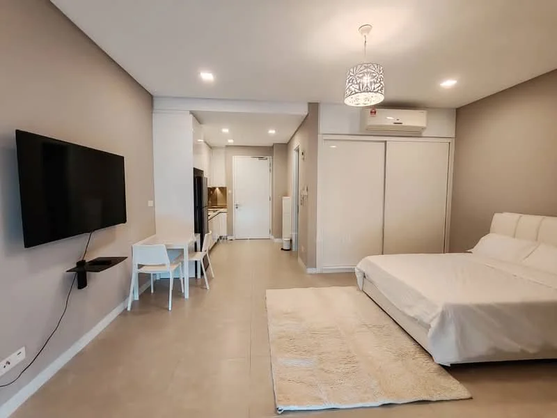 Room features: light grey painted walls, tile flooring, recessed downlights, wall-mounted TV, white bed with upholstered headboard, white bedding, white area rug, white dining table with two chairs, split air conditioning unit, sliding wardrobe doors, kitchen area visible in background; style: modern.