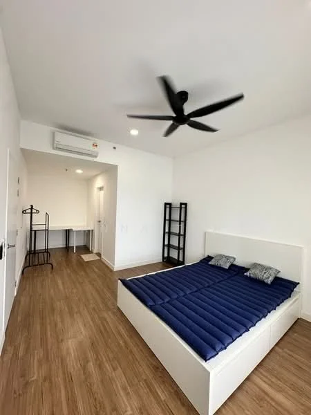 Bedroom features: king-size bed with blue bedding, wooden flooring, 5-blade ceiling fan, wall-mounted split AC, study desk, black metal clothing rack, black bookshelf, white painted walls, window with natural light; style: modern.