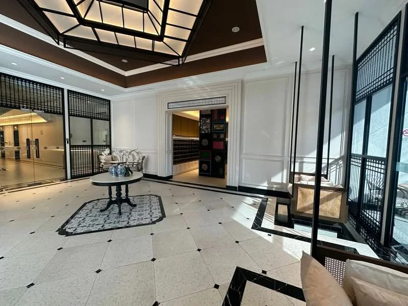 Room features: marble tile flooring, black and white patterned floor tiles, white painted walls, crown moulding, tray ceiling, chandelier, large windows, glass doors, decorative wall panels, recessed lighting, coffee table, upholstered seating, area rug; style: luxury; view: city.