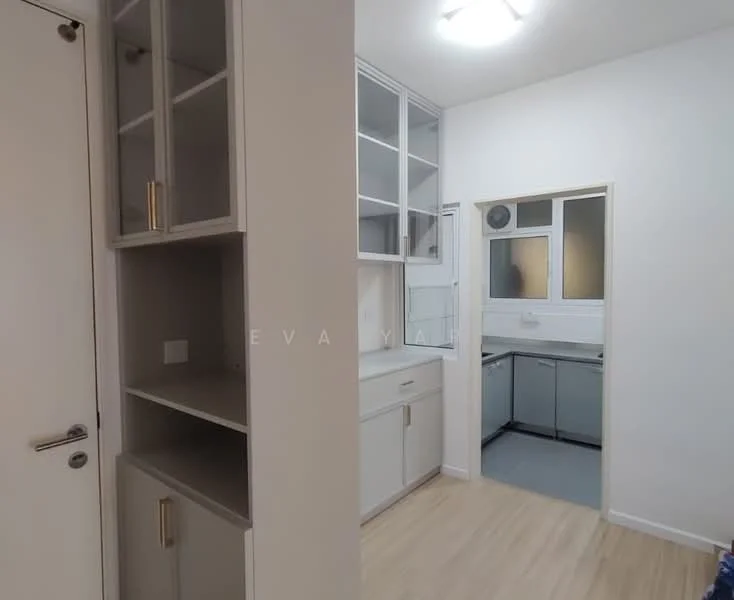 Room features: white painted walls, light wood flooring, built-in cabinetry with glass doors, countertop workspace, window with frosted glass, overhead lighting, open shelving, kitchen area visible in background; style: modern.