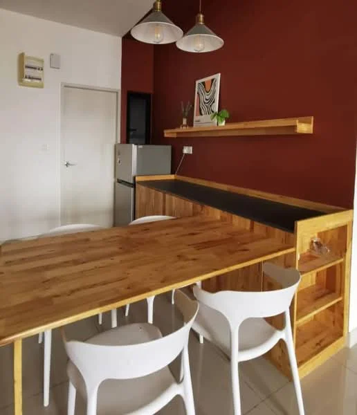 Dining features: wooden dining table, 4 white plastic dining chairs, brown accent wall, open shelving above the counter, black countertop, stainless-steel fridge, light fixtures with pendant lamps, cream tiled flooring, white painted walls, decorative artwork on wall; style: modern.