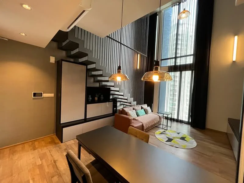 Living features: wooden flooring, grey accent wall, floor-to-ceiling windows, black vertical slats, 3-seater fabric sofa in beige, decorative cushions in various colors, round area rug with geometric pattern, hanging pendant lights, dining table with 4 chairs, wall-mounted air conditioning unit, built-in shelving unit; style: modern; view: city.