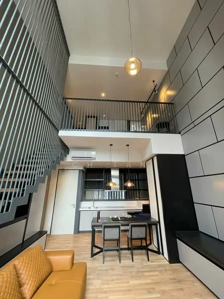 Living features: double-height ceiling, large windows, wooden flooring, open-plan layout, modern pendant light, black metal railing, sofa in tan leather, dining table with four chairs, kitchenette with cabinetry, air conditioning unit, wall-mounted shelves, neutral wall colors, staircase with metal railing; style: modern.