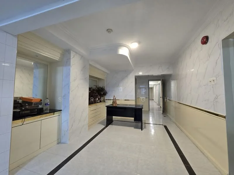 Room features: white marble wall cladding, cream painted walls, white tiled flooring, recessed ceiling with decorative moulding, built-in cabinetry with drawers, black console table, decorative plant arrangement, wall-mounted light fixture, long hallway, doorway leading to other rooms; style: modern.