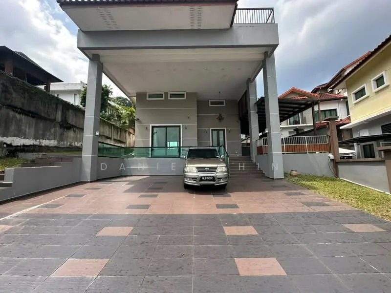 Exterior type: detached bungalow; features: flat roof, grey stone paving, manicured lawn, large driveway, covered porch, multiple windows, balcony on upper level, surrounded by greenery; style: modern.