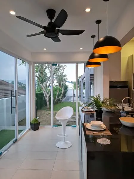 Dining features: 5-blade ceiling fan with light, pendant lights with orange shades, glass sliding doors, white walls, tile flooring, black countertop, white bar stool, decorative plant in pot, table setting with plates and cutlery, view of garden; style: modern; view: garden.
