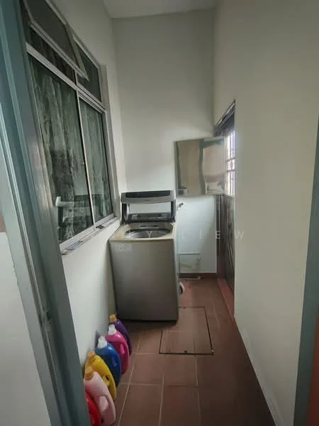 Laundry features: washing machine, grey stainless-steel washing machine, tile flooring in brown, window with metal frame, white walls, shelf above washing machine, laundry detergent bottles in various colors, drain access on floor.