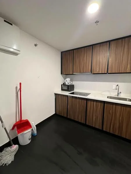Kitchen features: dark laminate flooring, white painted walls, brown wooden cabinetry, double-bowl stainless-steel sink, chrome pull-down faucet, built-in microwave, countertop with white surface, wall-mounted split AC, cleaning supplies including mop and bucket; style: modern.