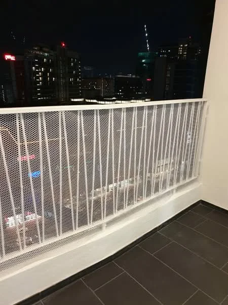 Room features: metal railing, black tiled flooring, city skyline view, night lighting, perforated metal screen; style: modern; view: city.