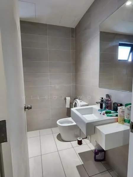 Bathroom features: grey tiled walls, white ceramic floor tiles, single-sink vanity with wall-mounted cabinet, chrome basin mixer faucet, framed mirror above sink, one-piece toilet, bidet spray, window for natural light, toiletries on vanity, toilet paper holder, hanging towel rack; style: modern.