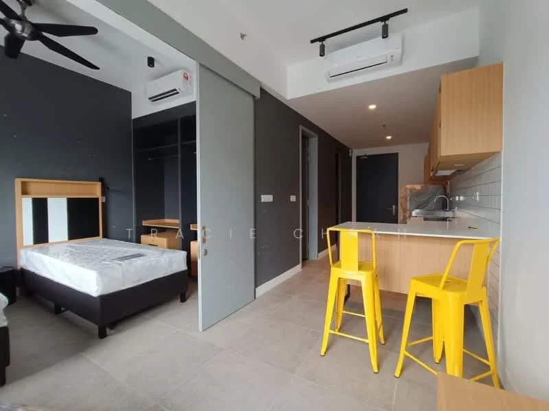 Room features: single bed, wooden bed frame, grey accent wall, light grey walls, tile flooring, ceiling fan, 2 yellow bar stools, kitchenette with wooden cabinetry, countertop, built-in wardrobe, air conditioning unit; style: modern.