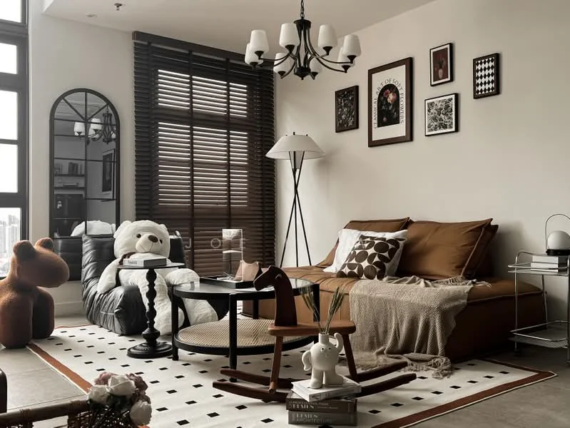 Living features: brown fabric sofa, decorative throw pillows, area rug with geometric pattern, wooden coffee table, floor lamp with white shade, chandelier with multiple bulbs, framed artwork on walls, large mirror, wooden rocking horse, teddy bear plush toy, decorative ceramic figurine, wooden side table; style: modern; view: city.