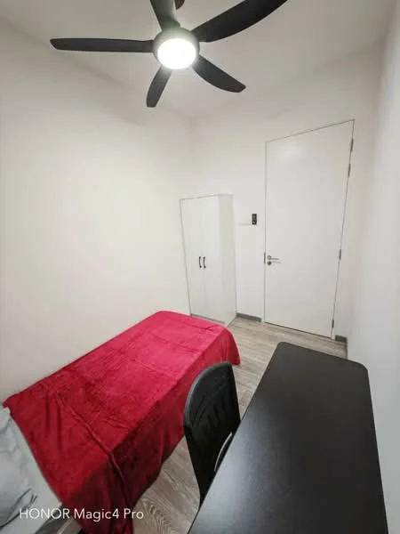 Bedroom features: single bed with red bedspread, black desk with chair, white wardrobe, light wood flooring, white painted walls, ceiling fan with light, door to hallway, window with no visible treatment; style: modern.