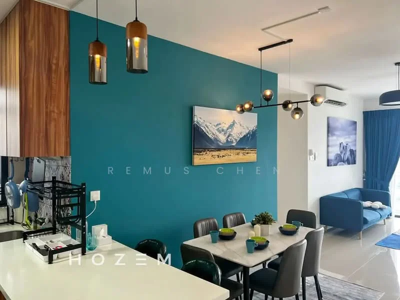 Dining features: blue accent wall, white ceiling, pendant light fixture with multiple bulbs, round dining table, 4 upholstered dining chairs, decorative artwork on wall, kitchen island with bar stools, open layout to living area, large windows with blue curtains, grey sofa in living area, neutral tile flooring, air conditioning unit on wall; style: modern.
