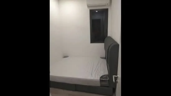 Bedroom features: queen-size bed, grey upholstered headboard, white painted walls, wooden flooring, 1 wall-mounted split AC, small window, nightstand, lamp; style: modern.